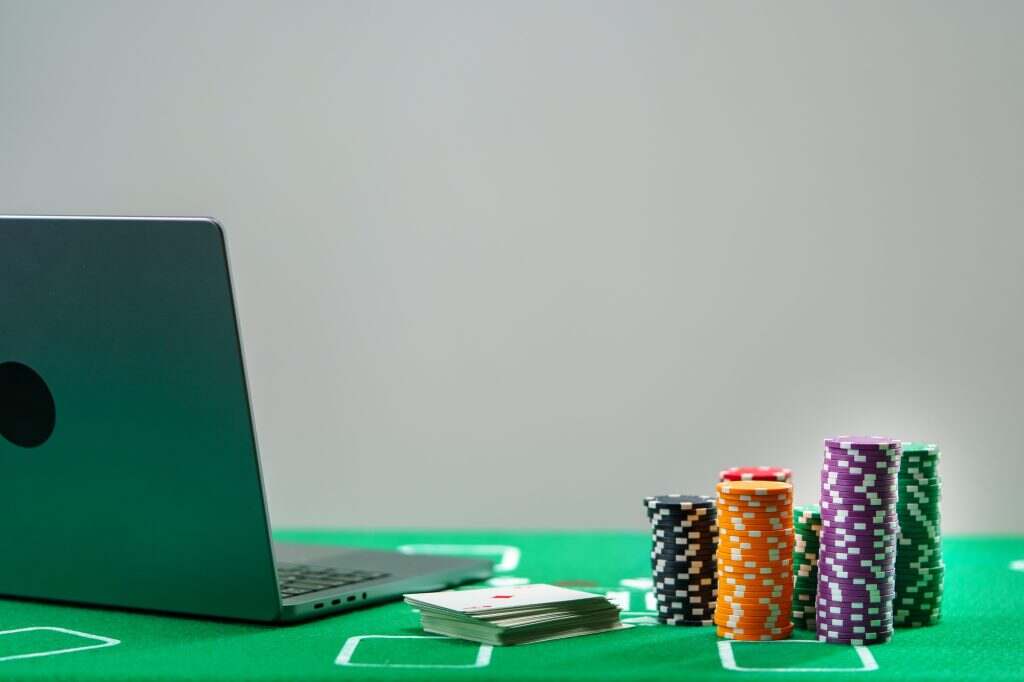 Online poker game setup with colorful chips and playing cards on a green table