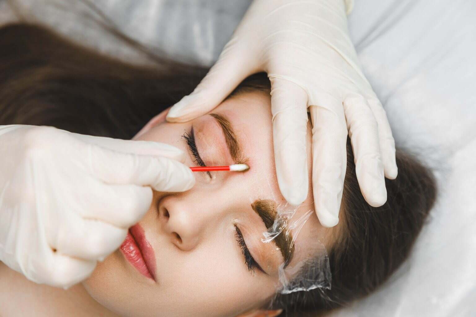 Comment faire pousser les sourcils : astuces et méthodes naturelles A cosmetologist applies permanent makeup to the eyebrows - eyebrow tattoo. eyebrow perm