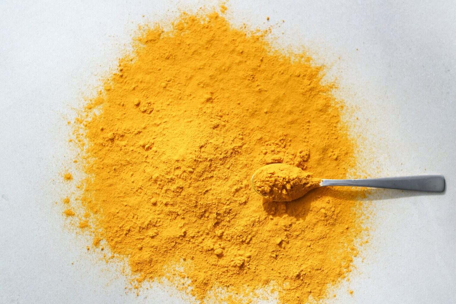 Les 15 principaux bienfaits du curcuma et comment l’utiliser Close up shot of turmeric curcuma in the spoon