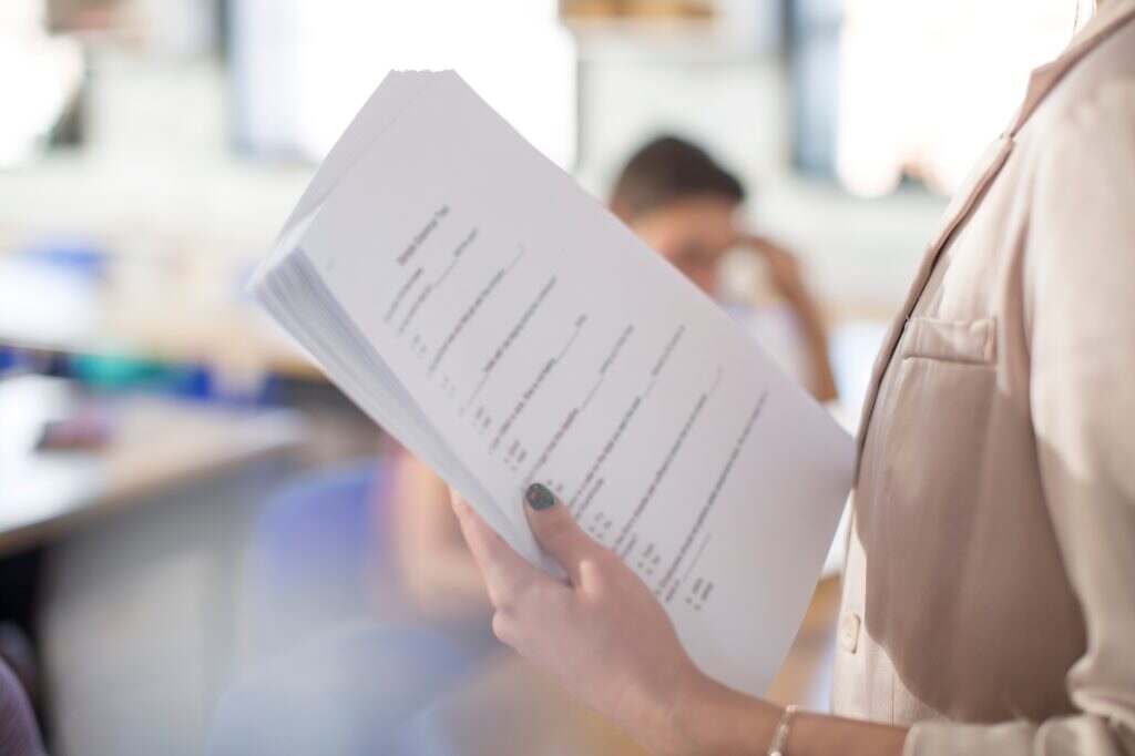 High school teacher with test notes in classroom