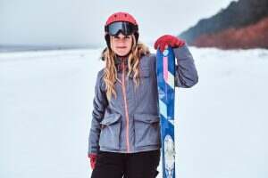 Norwegian woman wearing ski suit and posing with skis