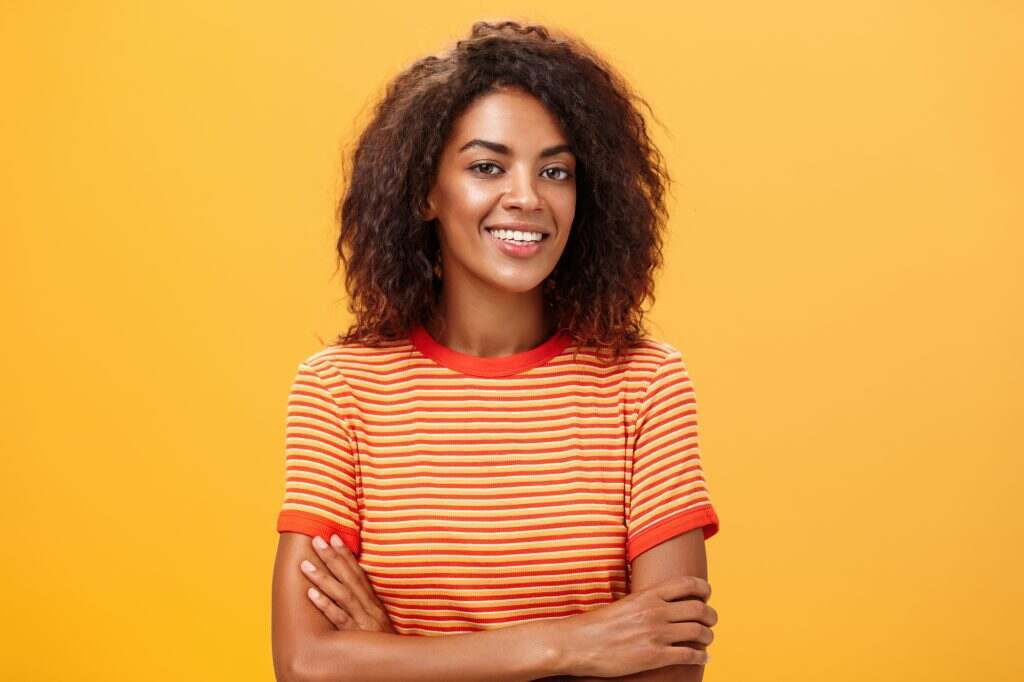 Waist-up shot of creative ambitious good-looking female coworker in trendy striped t-shirt holding