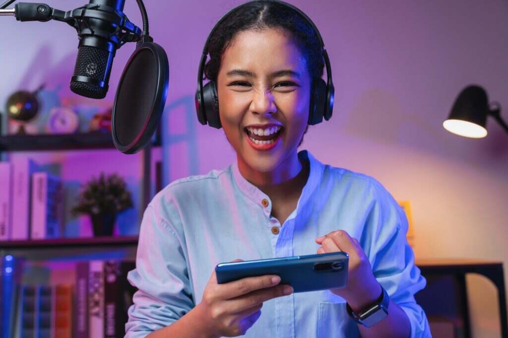 woman playing online game on smartphone with fists clenched celebrating victory expressing success.