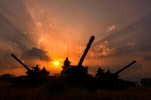 Army with battle tank at sunset time