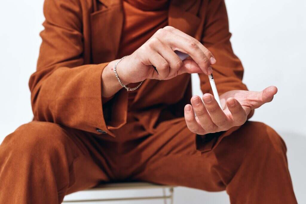 Fashion man portrait sitting cigarette beige smoking