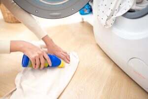 Female hand applying detergent to remove severe stains