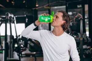 healthy sport man with whey shaker bottle. happy drinking whey protein for muscle strength mass gain