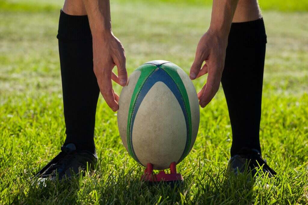 Low section of rugby player getting ready to kick for goal