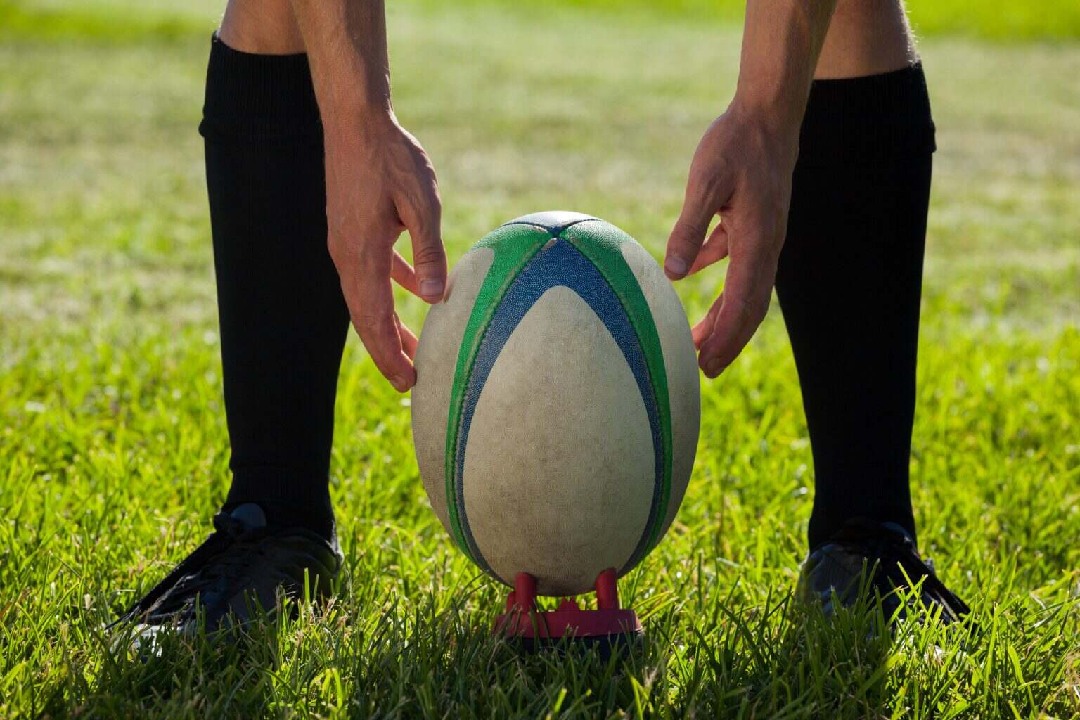 Low section of rugby player getting ready to kick for goal