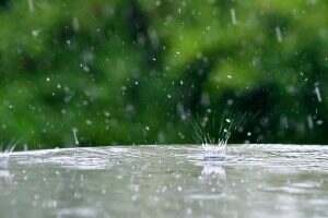 Rain splashing on a glass table during a summer rainstorm thunderstorm.