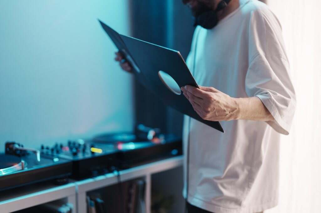 Dj preparing music with vinyl record and turntable