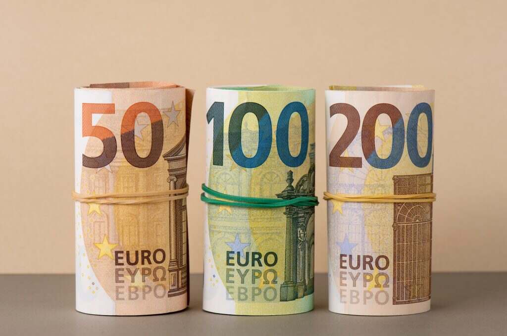 Euro in rolls background. Fifty, one hundred and two hundred euro bills are rolled up.