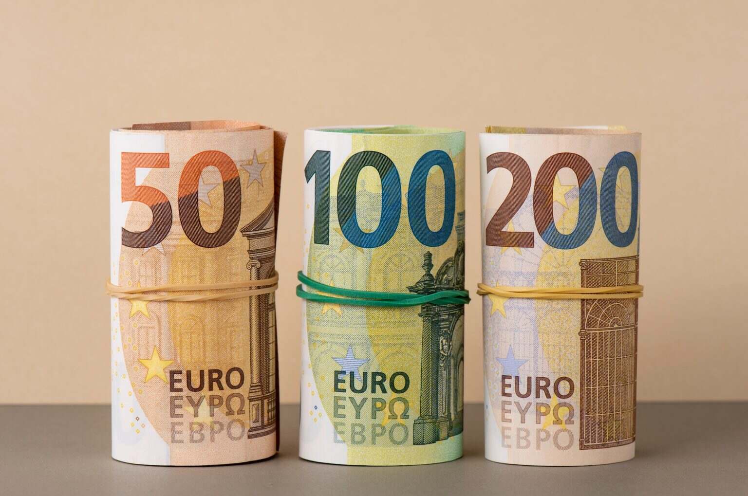 Euro in rolls background. Fifty, one hundred and two hundred euro bills are rolled up.