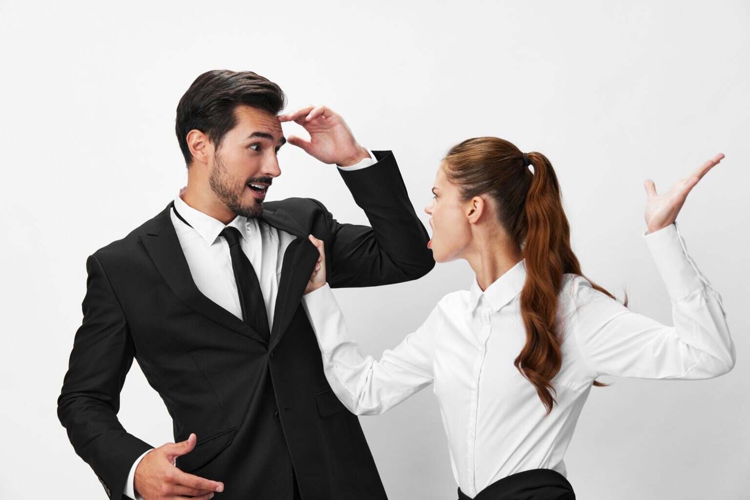 Man and woman anger business hitting on each other screaming with their hands up in the air on a