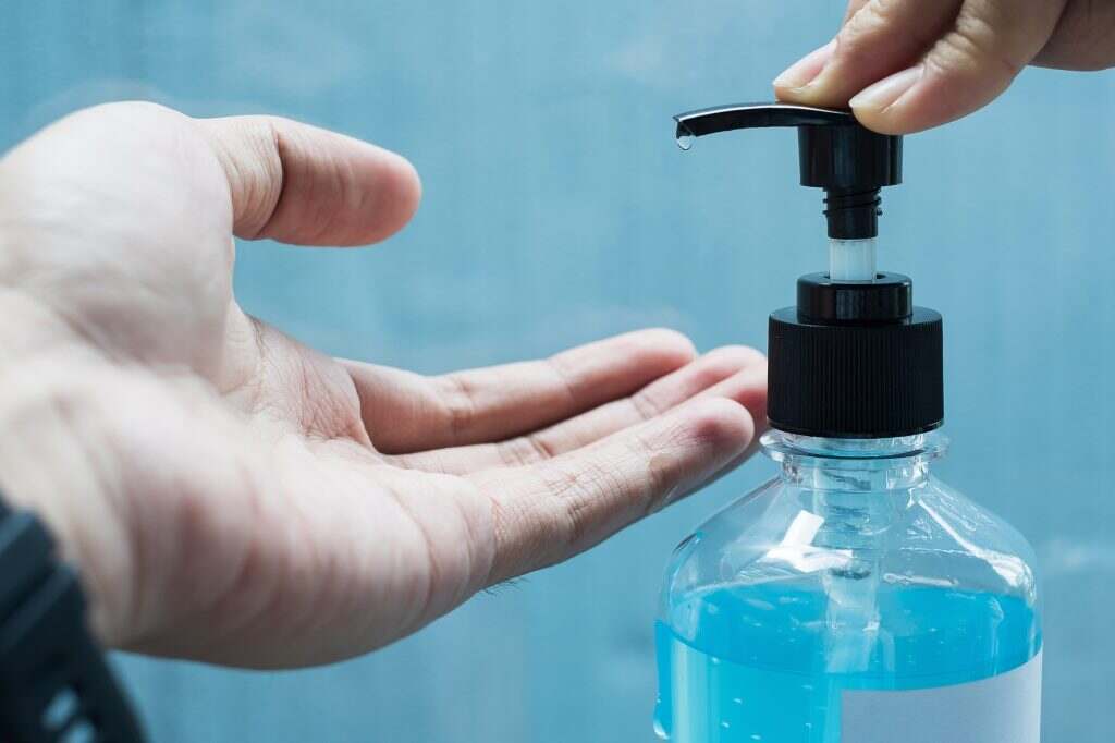 Man cleaning hand by alcohol sanitizer