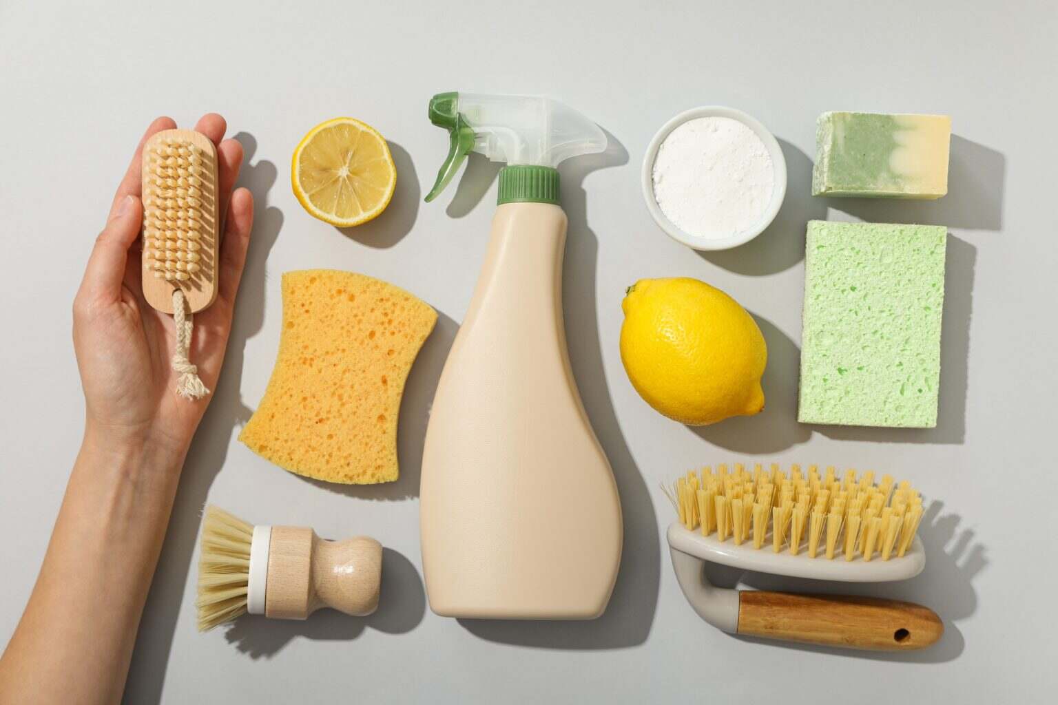 Spray bottle, cleaning tools,hand and natural cleaning products on gray background, top view