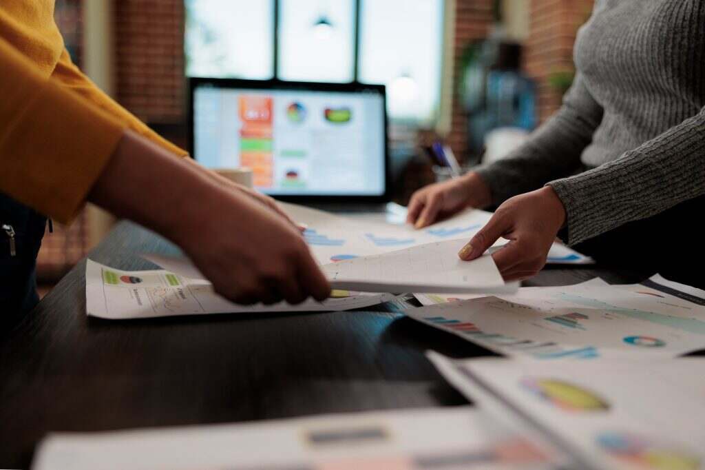 Close up of businesswomen holding papers with company graphs