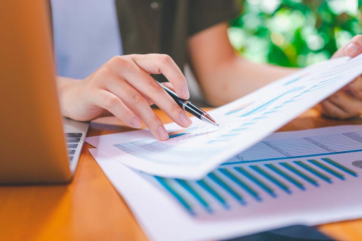 Freelance worker working on documents with graphs.