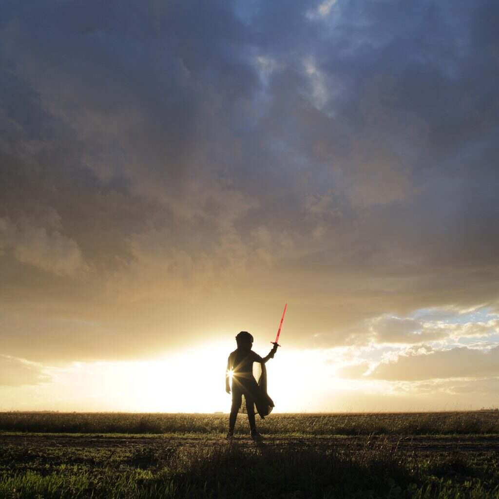 Star Wars. Lightsaber. Minimal person in the storm heavy clouds shining light power