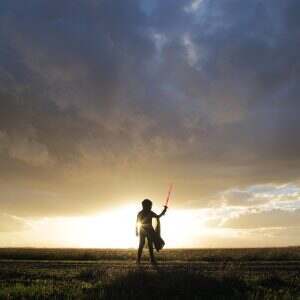 Star Wars. Lightsaber. Minimal person in the storm heavy clouds shining light power