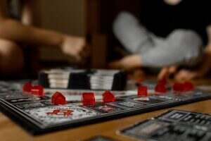 Boys, brothers play a board game. Children play monopoly