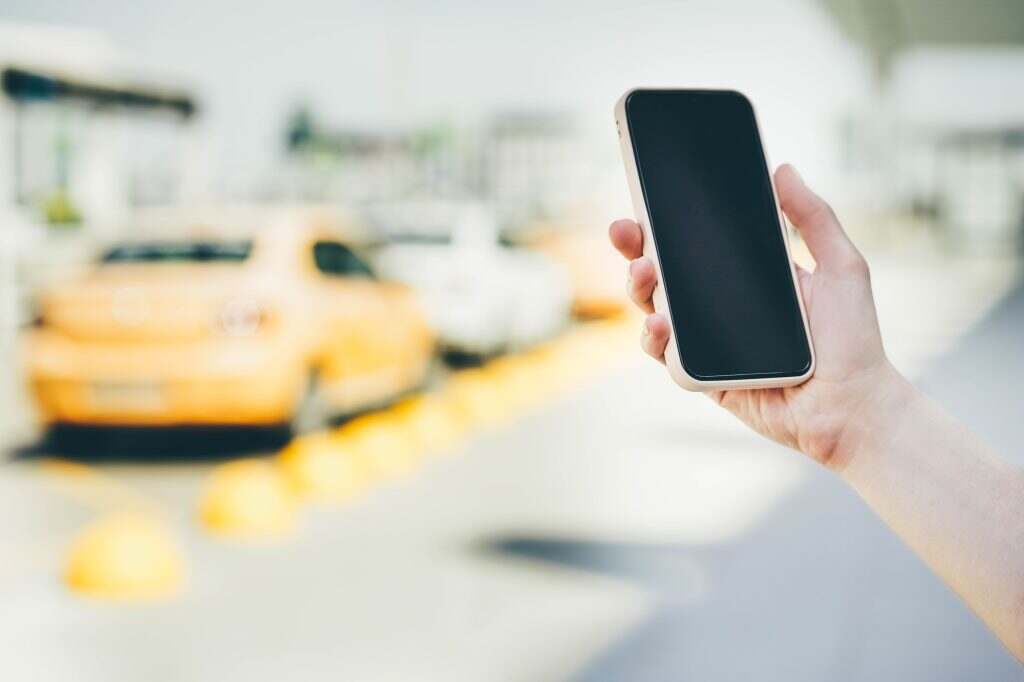 Waiting for taxi at airport. Concept of ordering a taxi with the mobile.
