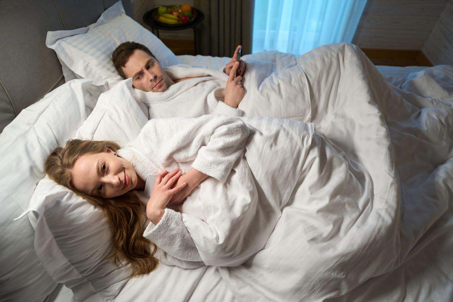 Happy woman hiding smartphone and smiling, risk of online treason