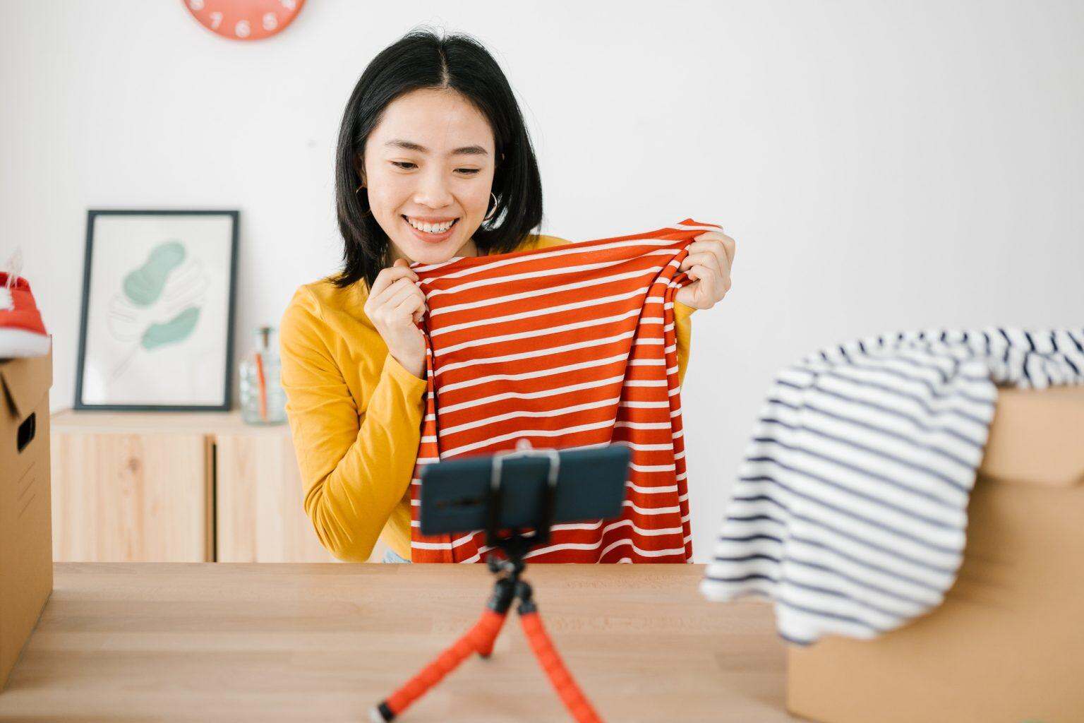 Young asian woman vlogging about news trends clothes product using mobile phone