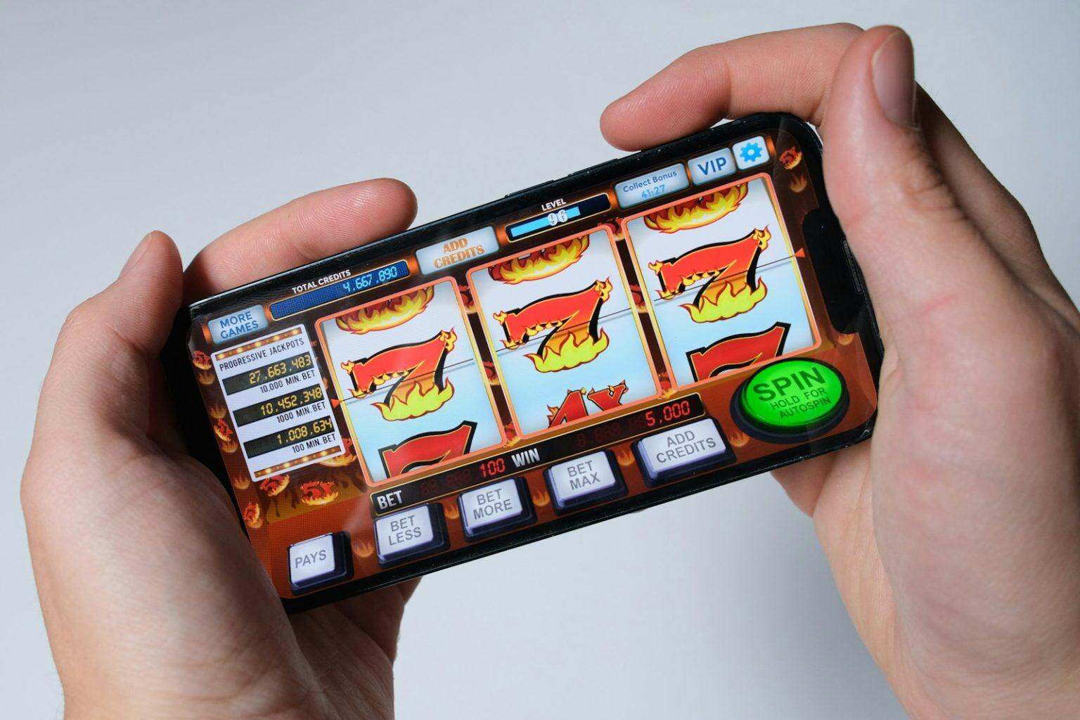 Addiction aux jeux d’argent : pourquoi votre cerveau vous trahit et comment s’en sortir Someone is playing a mobile slot machine game.