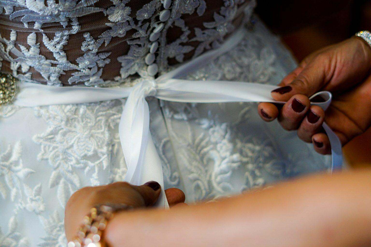 Comment choisir sa robe de mariée selon sa morphologie : révélations d’une styliste person holding white ribbon on white and gray floral textile