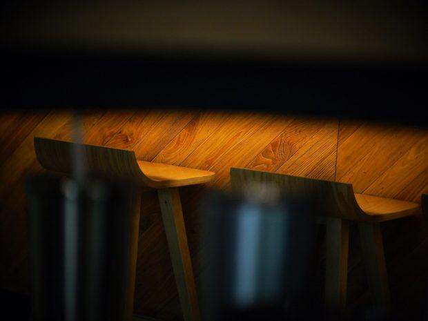 a row of wooden stools sitting on top of a wooden floor