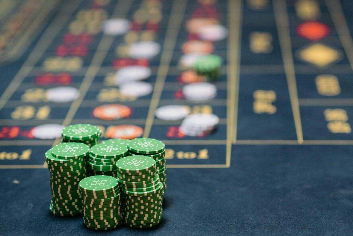 Stack of green poker chips on a casino table, highlighting the gambling theme.