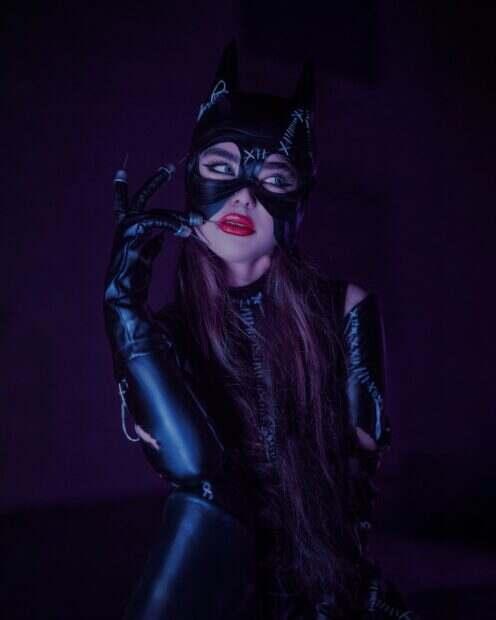 a woman wearing a cat mask and latex gloves