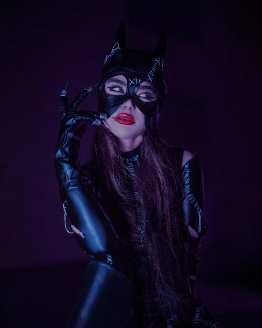 a woman wearing a cat mask and latex gloves