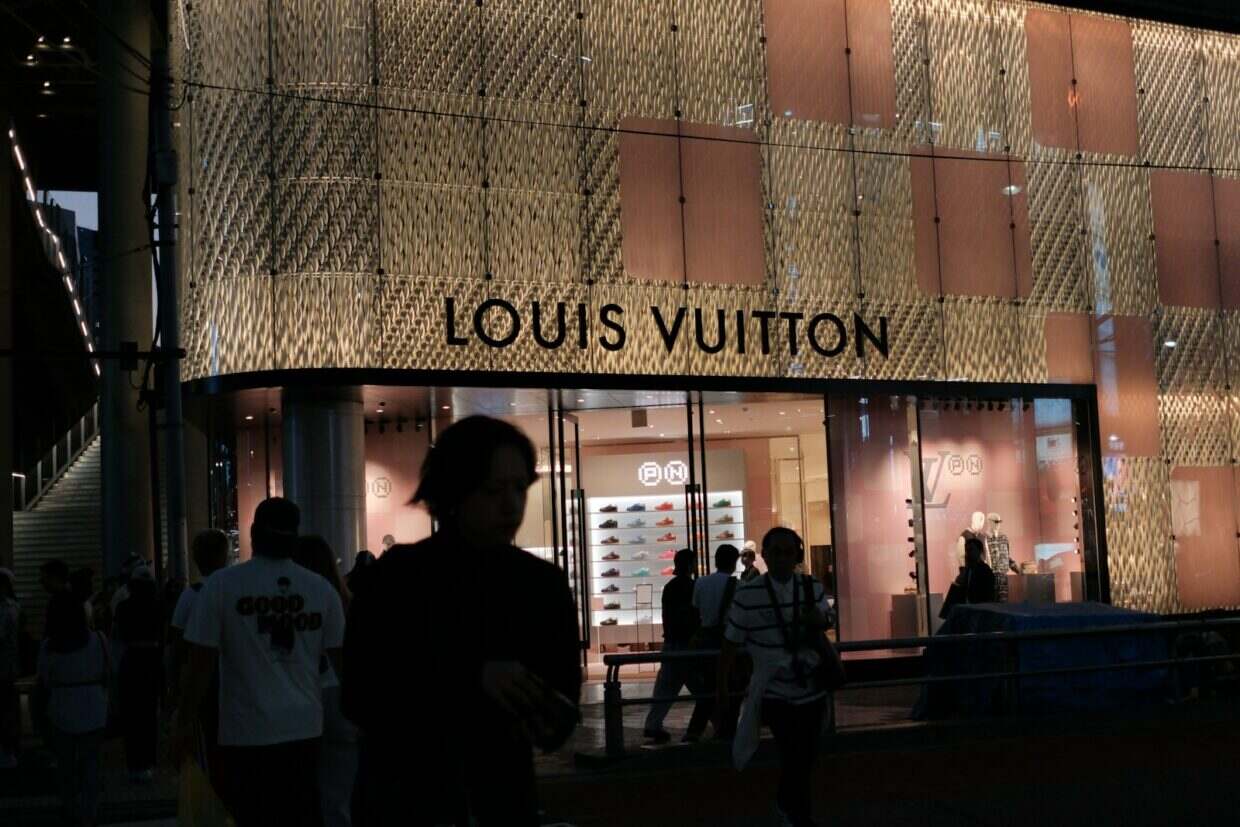 Louis vuitton store exterior at night with people.