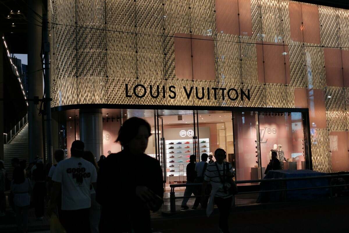 Louis vuitton store exterior at night with people.