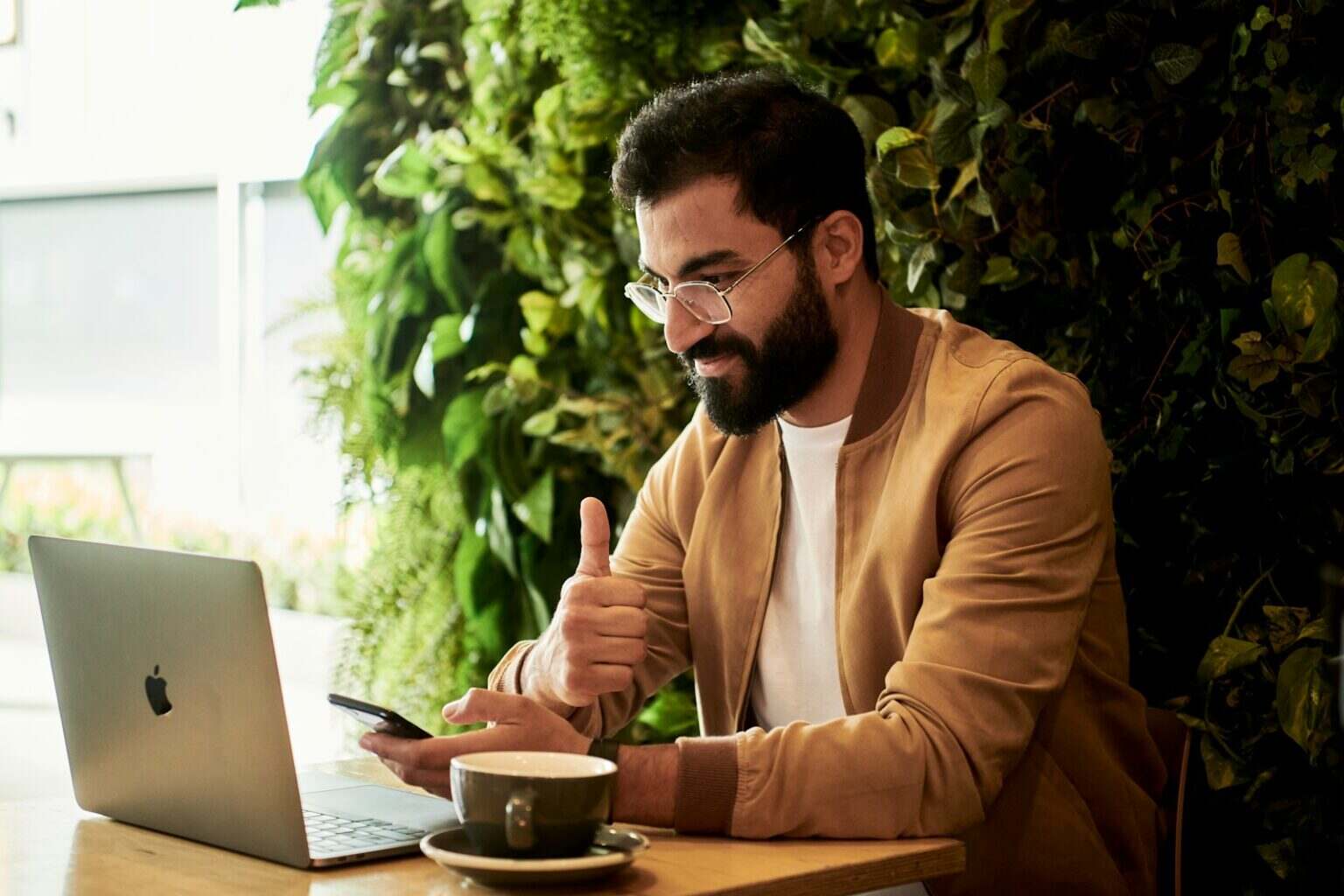 Comment aider les petites entreprises à prospérer : 7 actions concrètes pour soutenir l’économie locale man in brown jacket sitting at a table looking at laptop