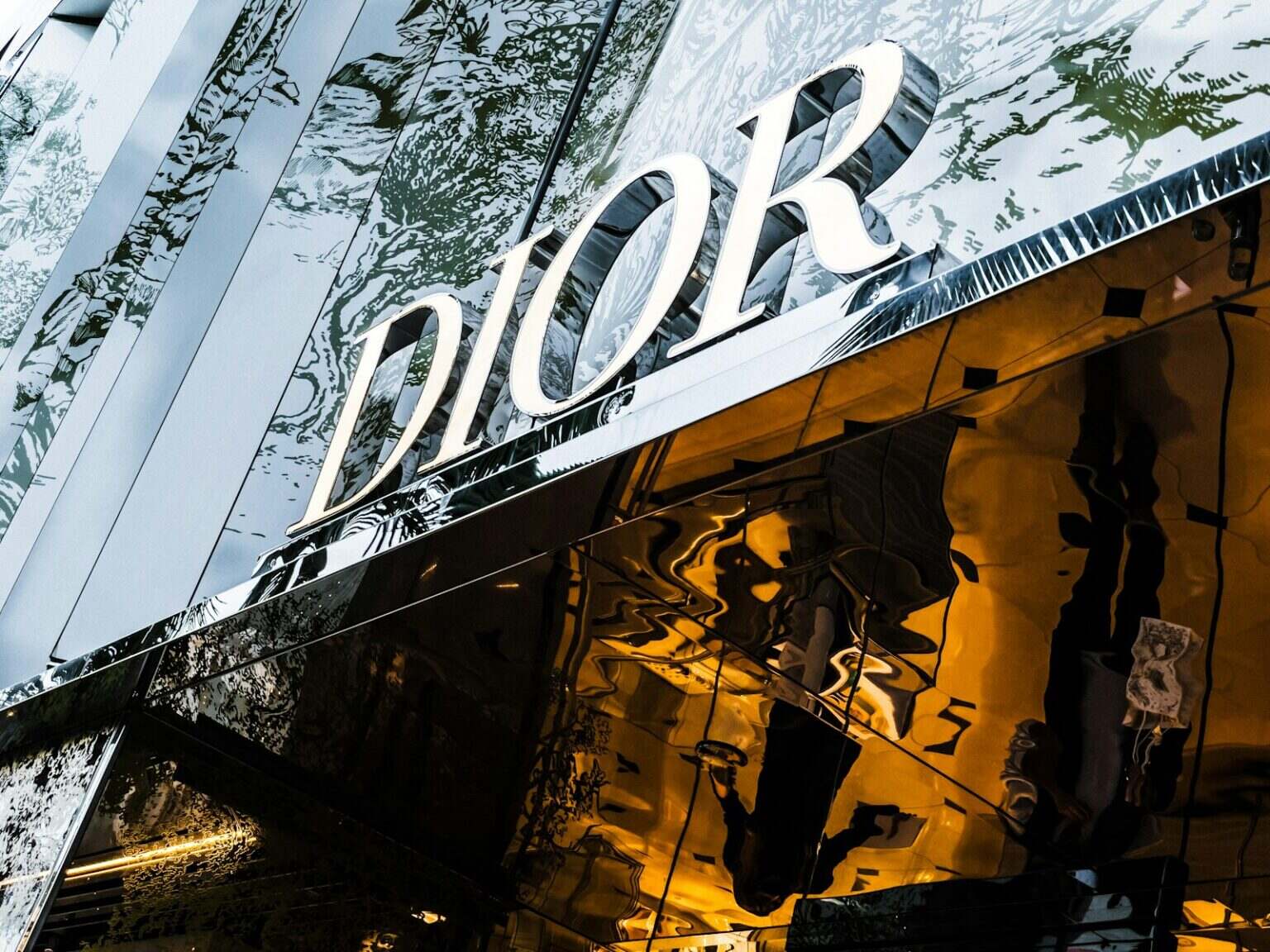 Comment reconnaître une vraie marque de luxe ? a reflection of a building in the windows of another building