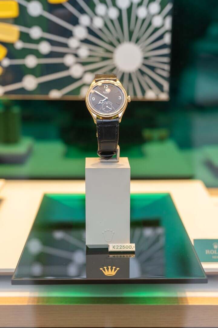 Gold wristwatch with black leather band displayed