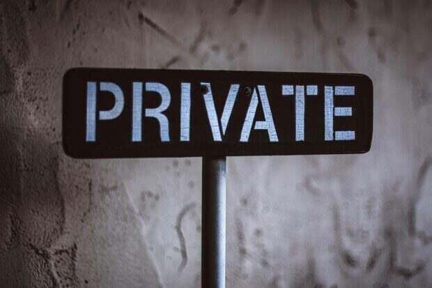 A weathered 'Private' sign on a rustic wall background in Solvang, California.