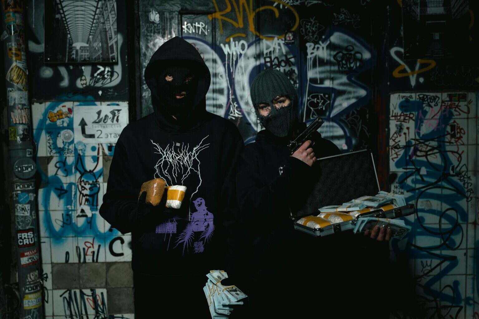 Quelle est vraiment la ville la plus dangereuse de France ? Two masked individuals holding packages and a gun in a graffiti-covered alley.