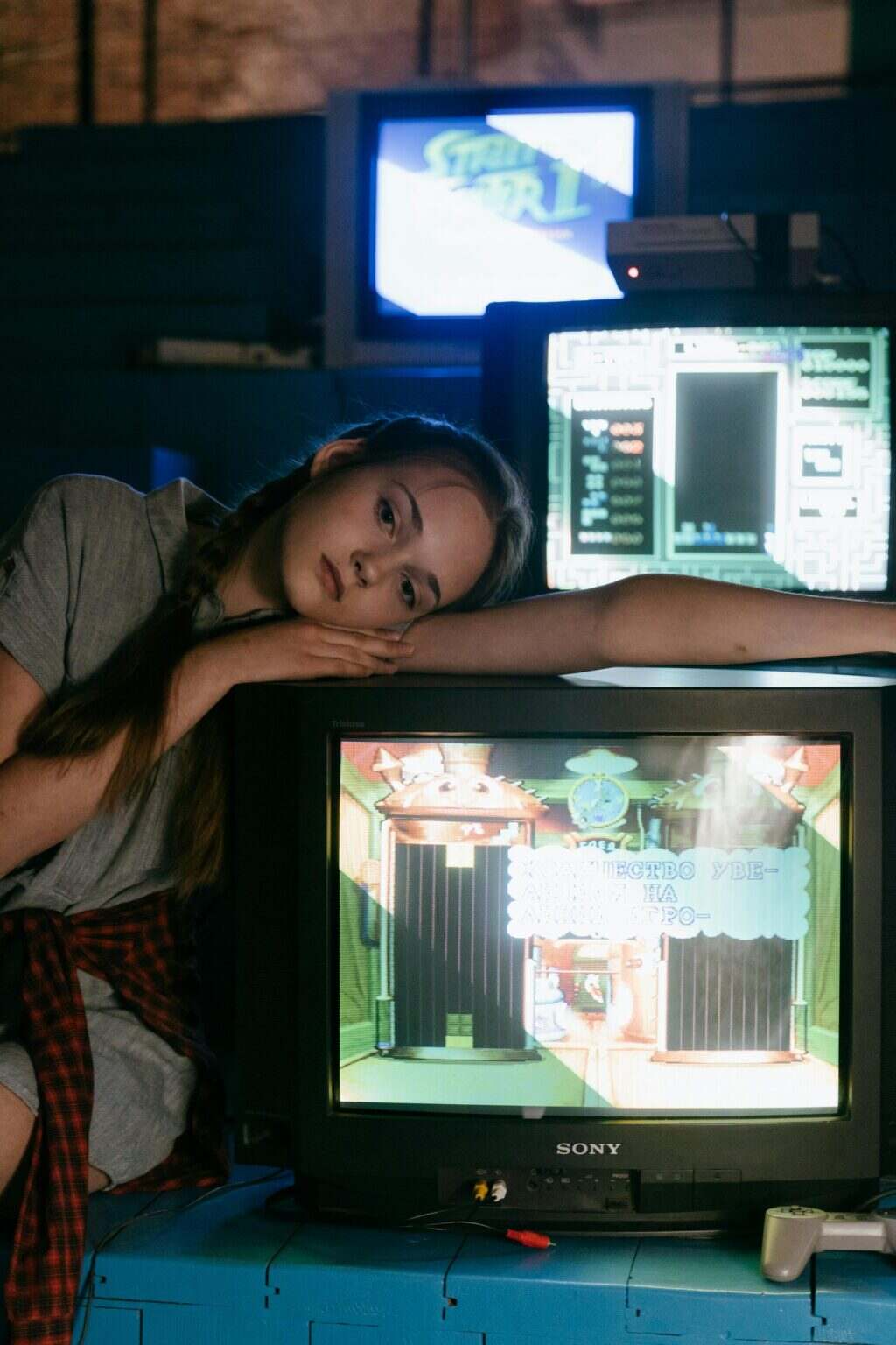 Les Mystères des Profondeurs : Explication de la Révélation du Monde À l’Envers dans la Saison 5 de Stranger Things Teenage girl with pigtails in vintage arcade, 80s vibe, playing video games indoors.