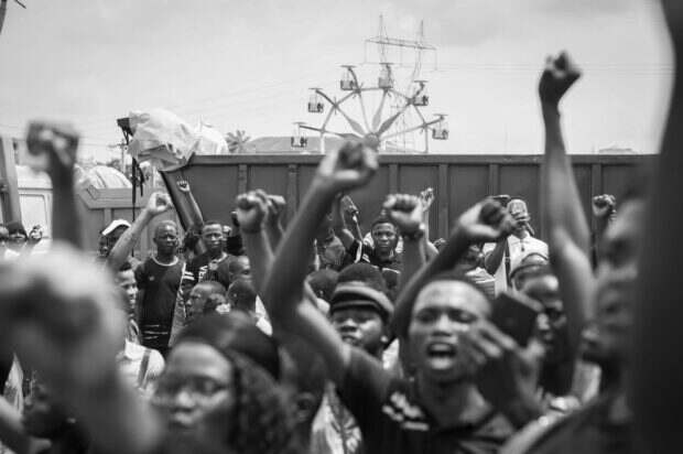 Jesse Jackson s’éteint à 84 ans : la voix qui refusait de se taire vient de s’éteindre Black and white photo of a large crowd raising fists, showcasing unity in protest.