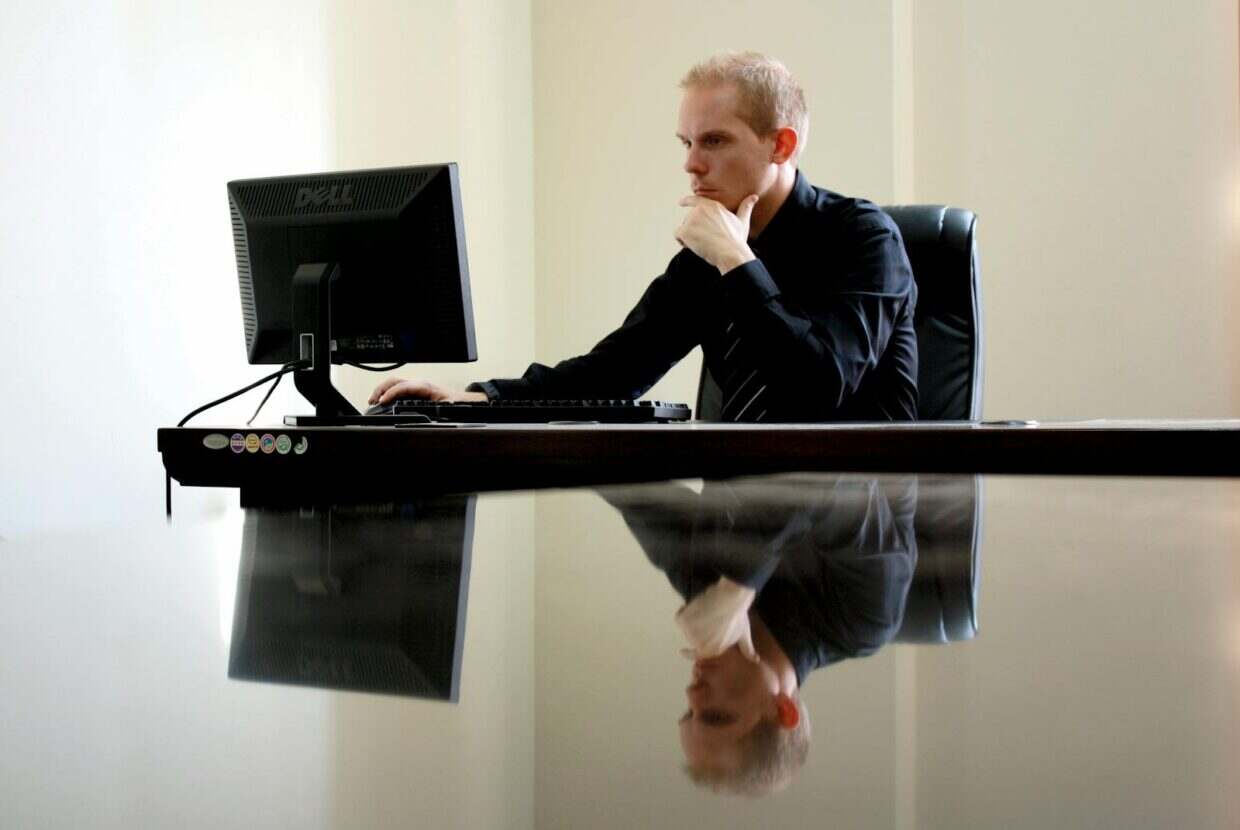 A businessman in deep thought at his desk, reflecting on work tasks.