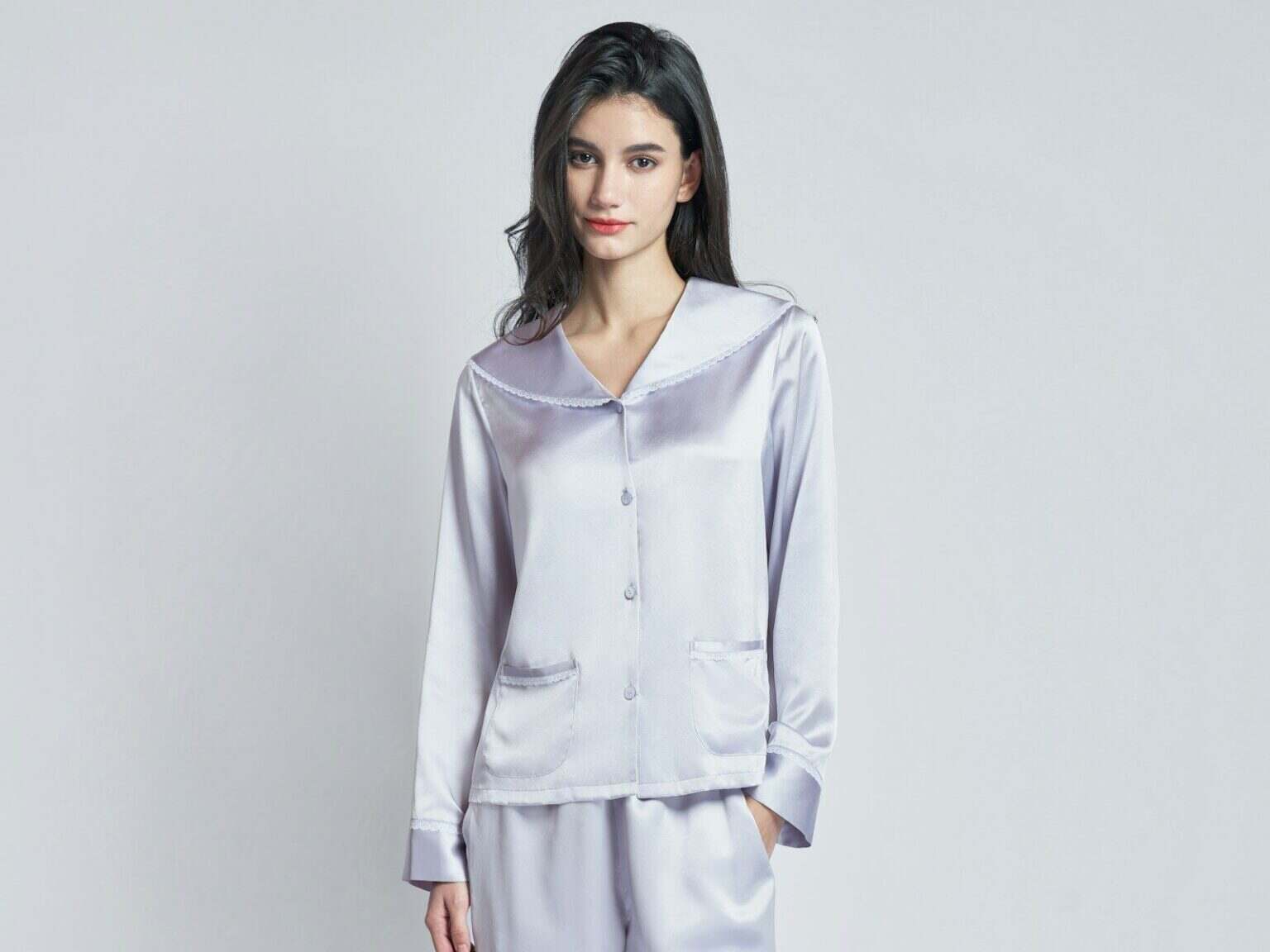 A woman wearing a light purple silk pajama set.