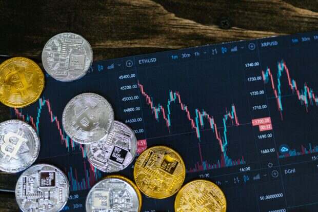 L’argent explose : pourquoi le métal blanc affole les marchés en 2026 Close-up of gold and silver cryptocurrency coins on a digital trading chart.
