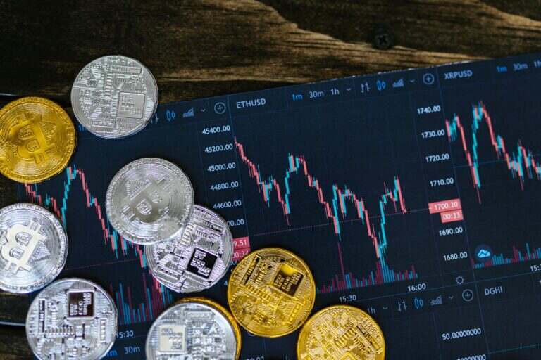 L’argent explose : pourquoi le métal blanc affole les marchés en 2026 Close-up of gold and silver cryptocurrency coins on a digital trading chart.