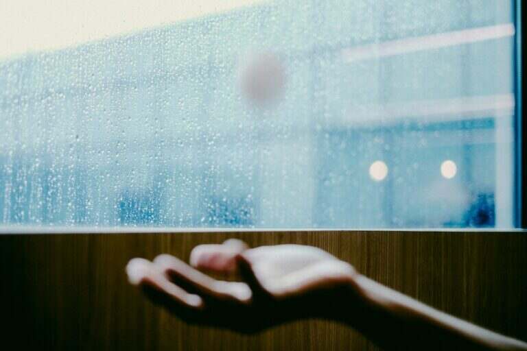 persons hand on glass window