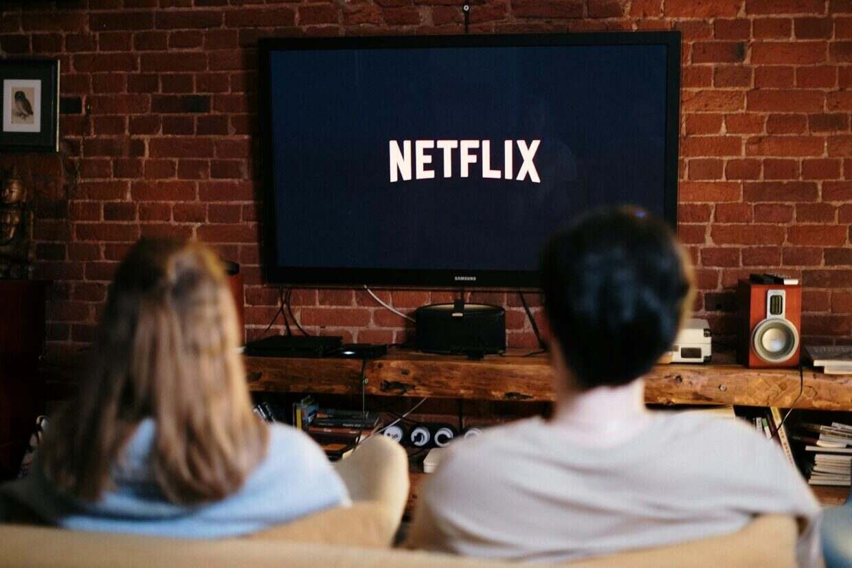 A couple relaxing and watching Netflix in a cozy living room setting.