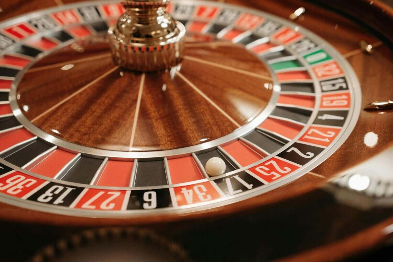 Combien rapporte le 0 au casino : ce que la bille verte change vraiment A detailed close-up of a spinning roulette wheel with the ball in play, capturing the essence of casino excitement and gambling.